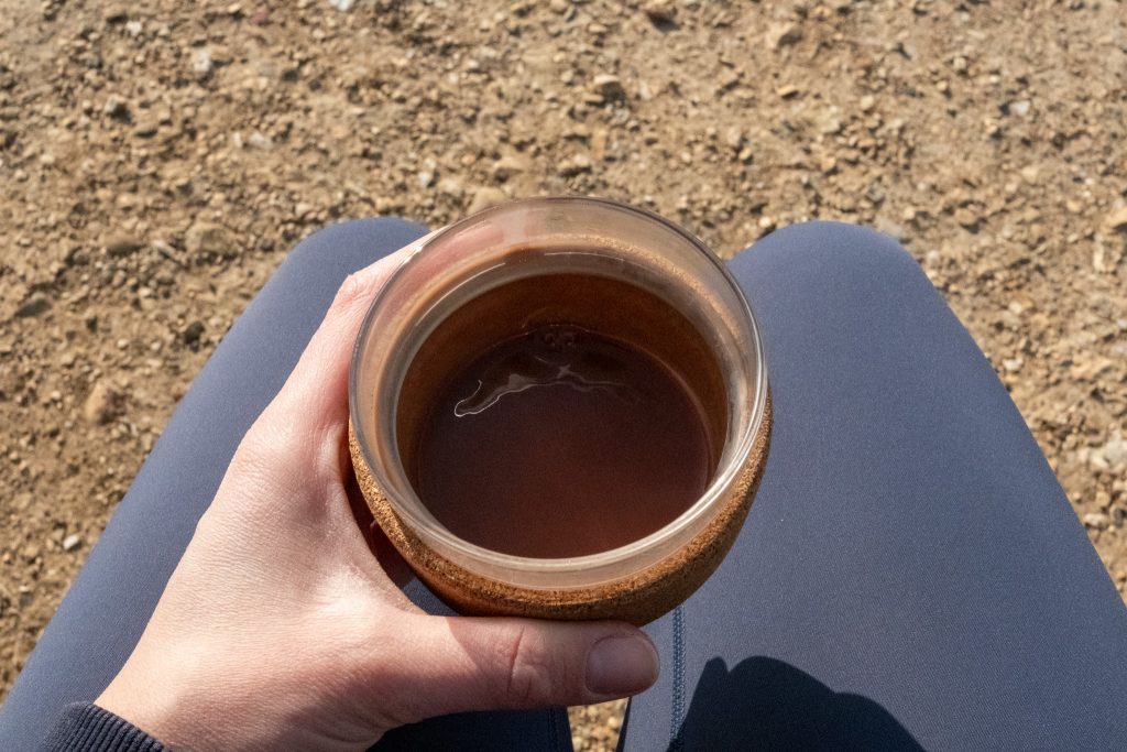 Healthy, vegan hot chocolate in a travel cup being enjoyed on a walk
