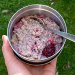 A bowl of berry and chia seed porridge being enjoyed in the garden